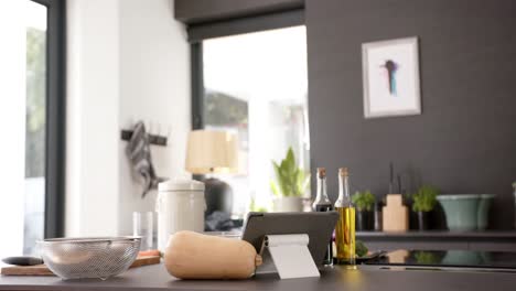 general view of countertop with pumpkin, oils and tablet in kitchen, slow motion