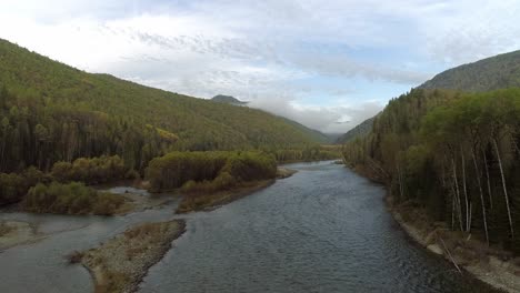 aerial view of a river winding through a forest and mountains