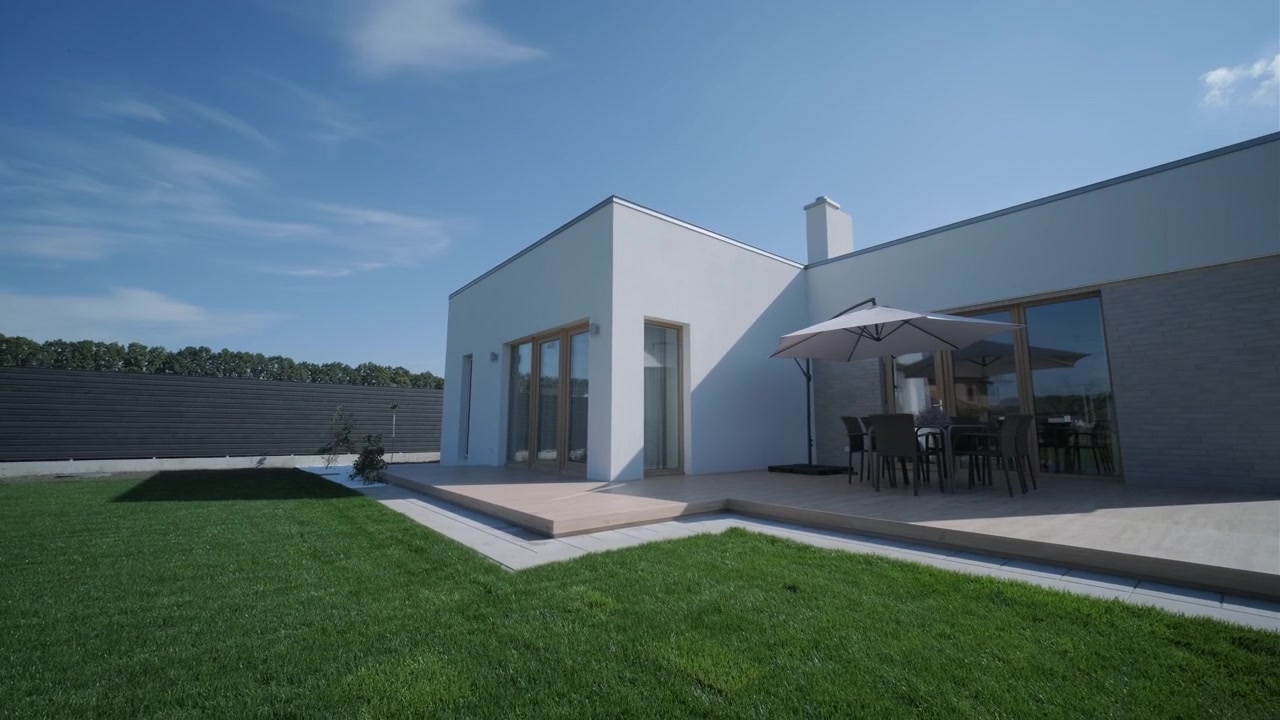 Casa bianca moderna con terrazza in legno e giardino