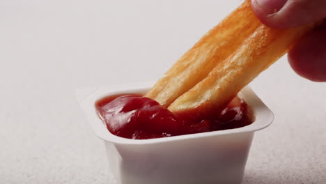 french fries dipping into ketchup