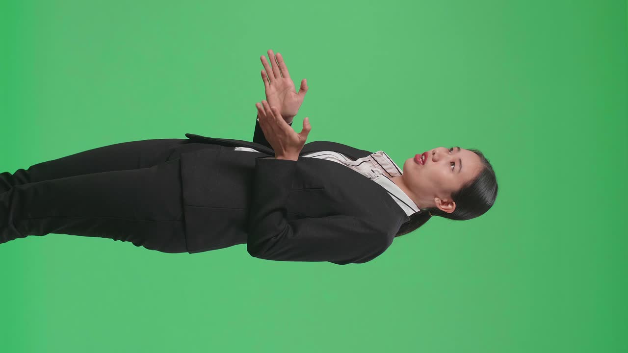 Side View Of Asian Businesswoman In Suit Jacket Standing And Presenting Something On The Green Screen Background