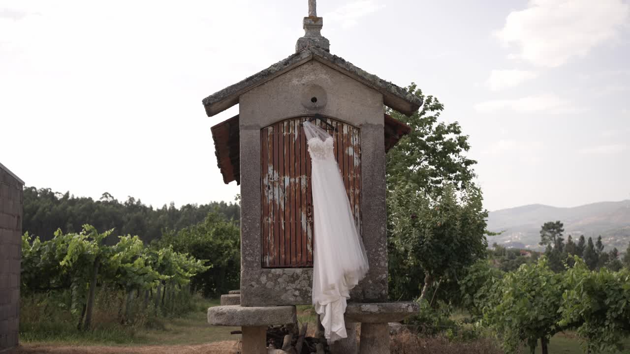 lace wedding dress elegantly Hung on Rustic Espigueiro in Minho, Northern Portugal
