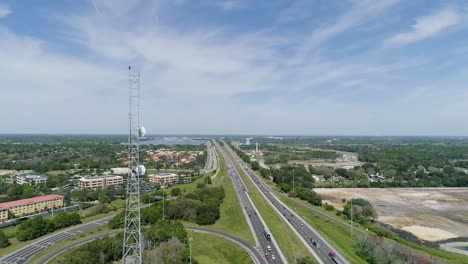 Toma-Panorámica-De-Una-Torre-De-Radio-Al-Lado-De-La-Autopista-En-Florida-En-Un-Día-Soleado