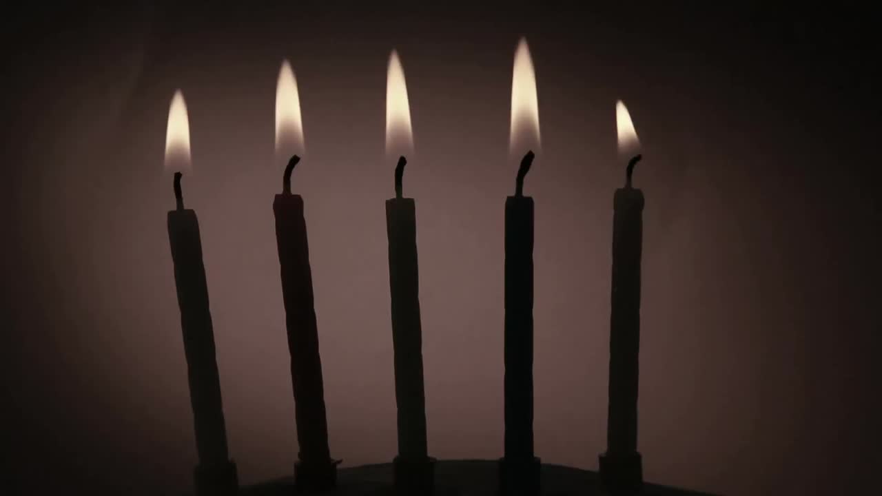 Animazione di documento in fiamme su candele accese per torta di compleanno