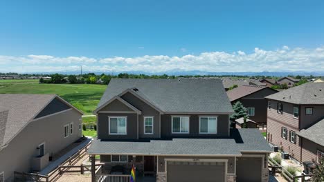 Descending-drone-shot-of-house-with-transgender-and-LGBTQ-pride-flag-on-porch