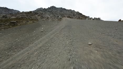 drone flight up a rocky mountain with snow patches in tyrol region of austria