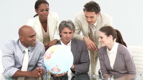 equipo de negocios multiétnico mirando un globo terrestre