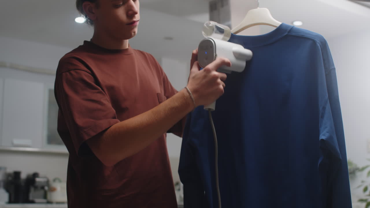 Caucasian Man Steaming Sweater at Home