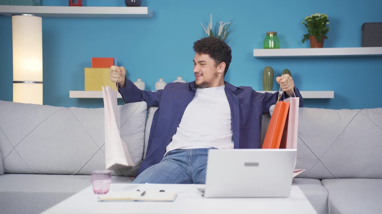 쇼핑백을 들고 카메라를 보는 남자.