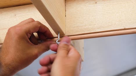 Men-screwing-a-crew-in-a-wooden-structure-close-up