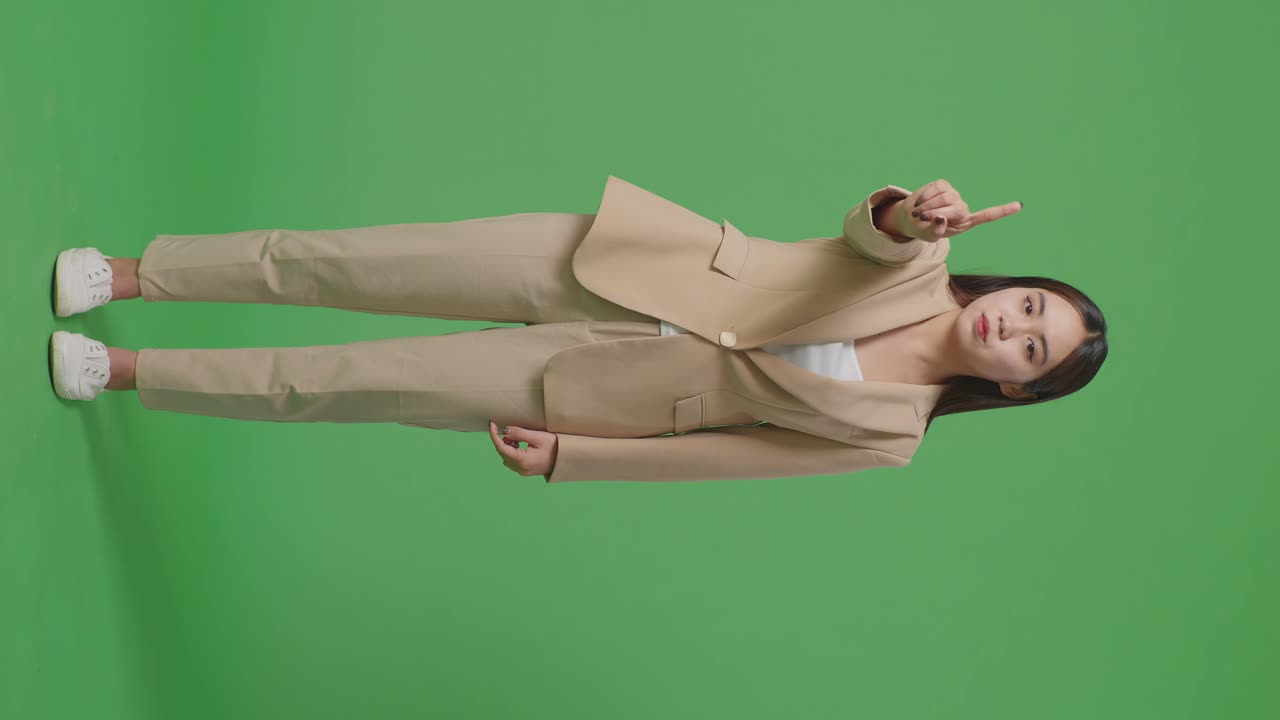 아시아 사업가 여성의 몸이 가득 차 있습니다. 스, 한 손가락 제스처, 금기 표지, 스튜디오의 녹색 화면에 서 있습니다.