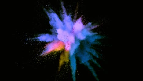 super slow motion of colored powder explosion isolated on dark background.