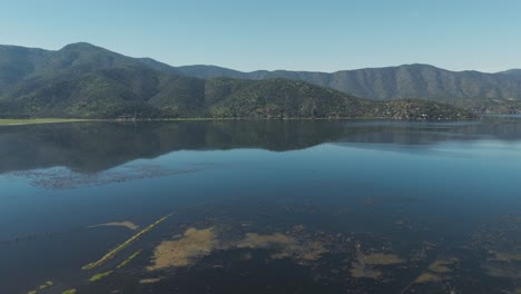 impresionante vista aérea de la laguna de aculeo rodeada de exuberantes colinas en chile