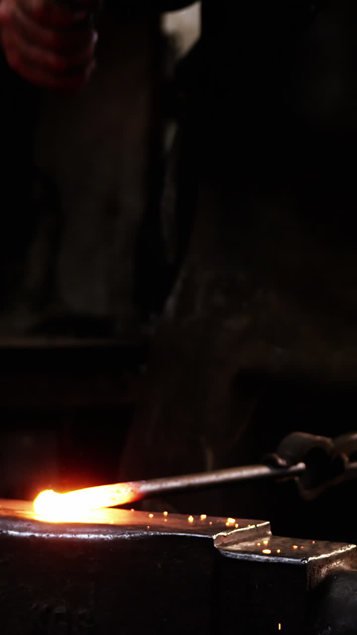 sección media de un herrero trabajando en una barra de hierro