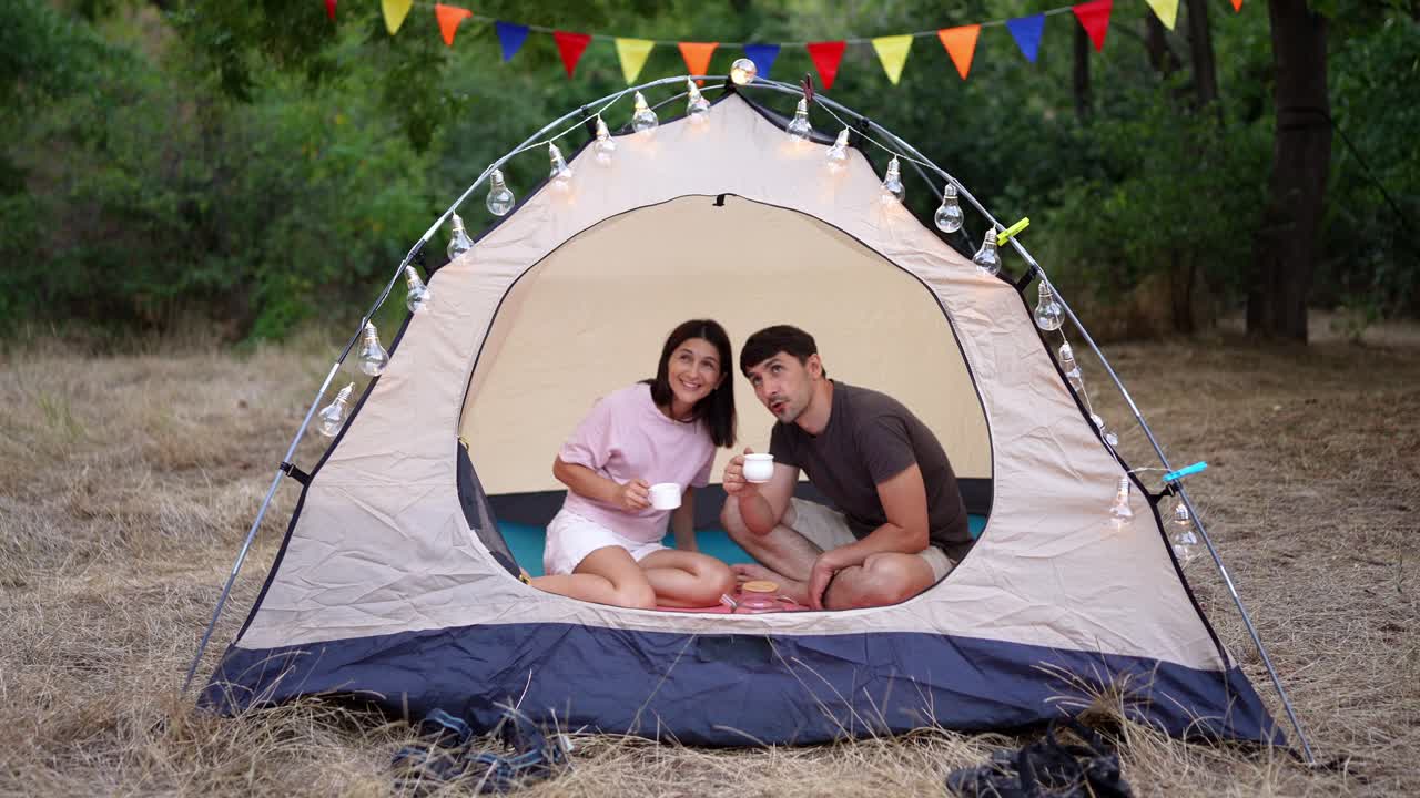 밤 에 텐트 에서 휴식 하는 부부