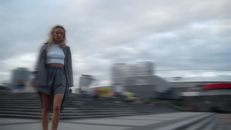 girl walking down stairs in city centre urban buildings background.