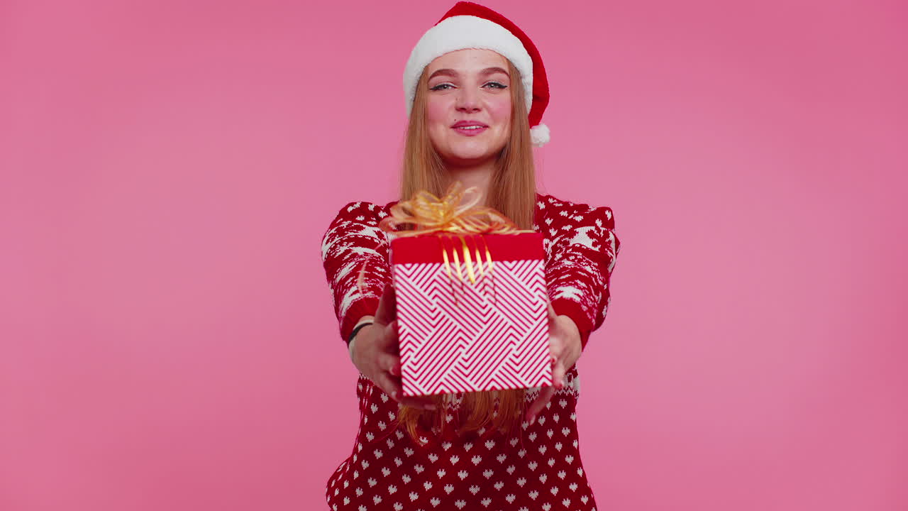 chica alegre en suéter de navidad rojo con ciervos presentando caja de regalos de navidad, compras venta de vacaciones