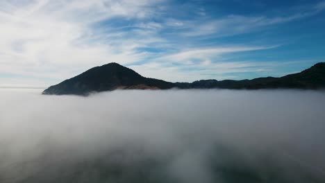 공중: 오레곤 해안의 산을 드러내기 위해 안개가 자욱한 바닥 위로 상승
