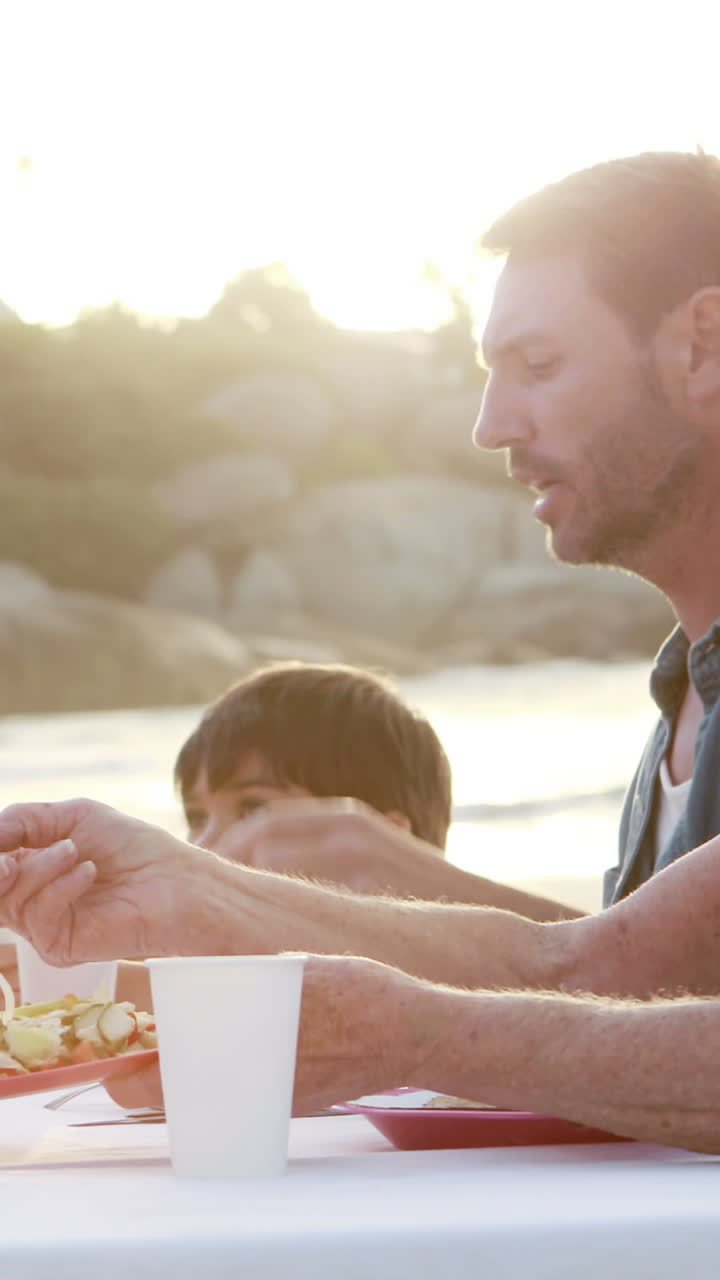 tres generaciones sonrientes de la familia comiendo juntos