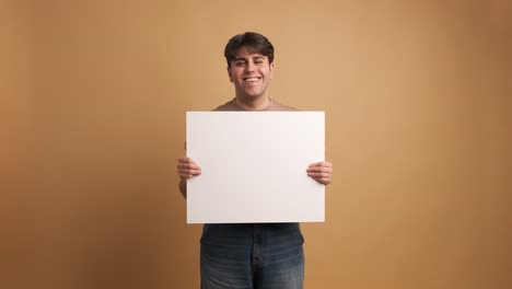 cheerful man showing blank banner in studio