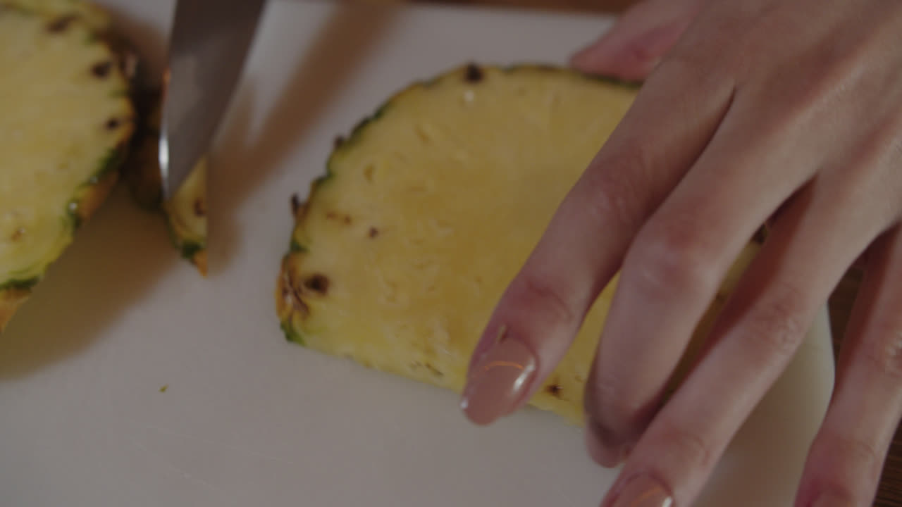 칼이 파인애플의 질을 잘라서 조각으로 잘라서 유명한 피나 콜라다 테일을 준비하는 놀라운 느린 동작 촬영