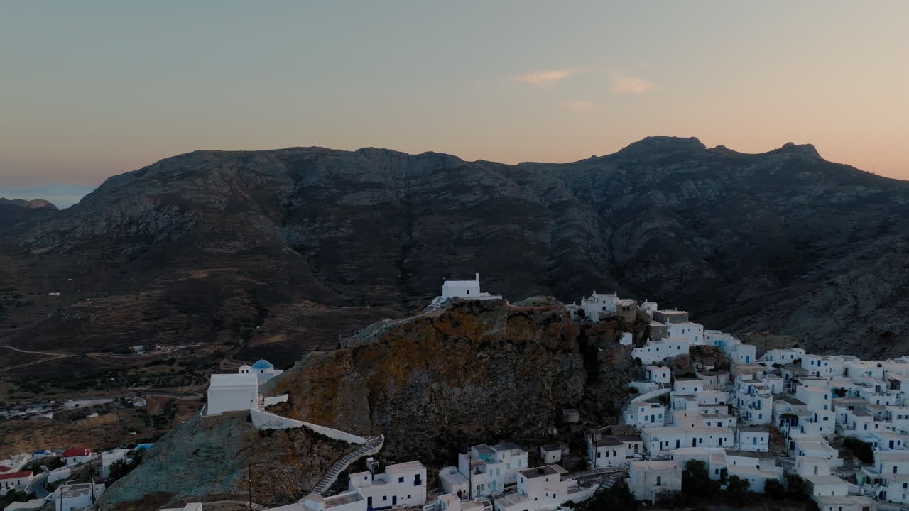 Overhead establishing of white Cycladic houses in Serifos Chora at dusk with chapel on the peak