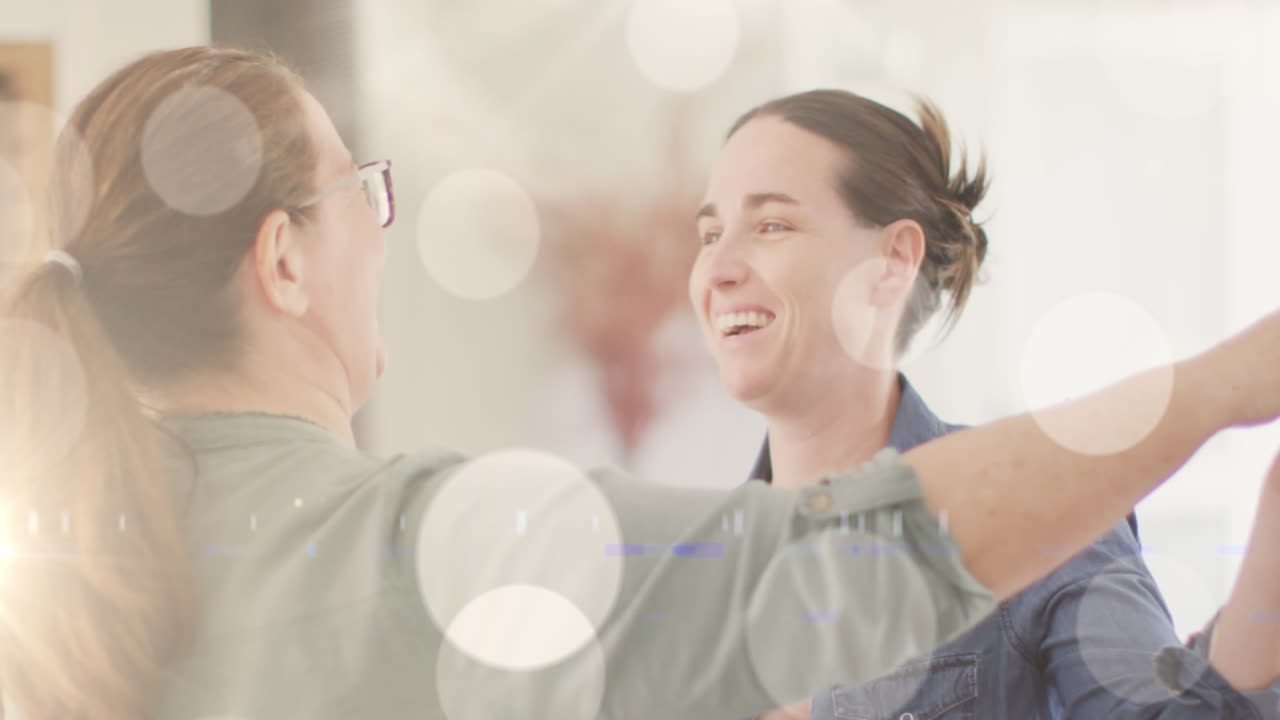 백인 여성 동성 커플이 배경에서 춤을 추는 백인 여성 게이 커플 위에 빛의  점의 애니메이션