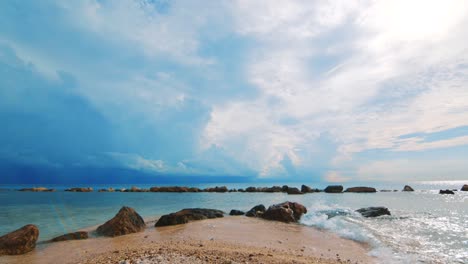 Slowmo-Sanfte-Wellen-Brechen-Am-Karibischen-Sandstrand-Mit-Gewitterwolken-Dahinter