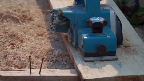 close up shot of a carpenter hand using planer machine