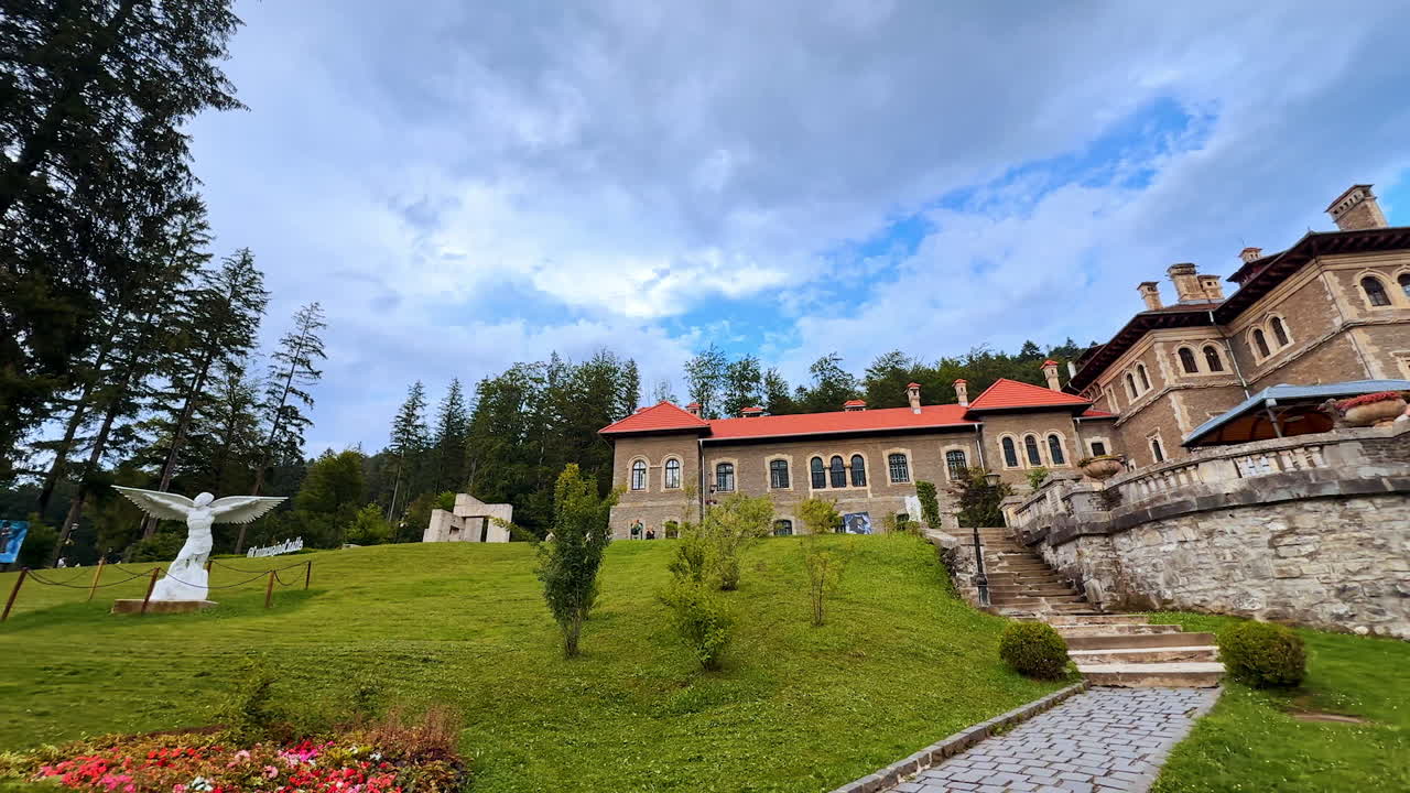 Busteni, Romania, 17 July 2025: Famous Cantacuzino Castle in Busteni, Romania. Beautiful territory and castle against cloudy sky