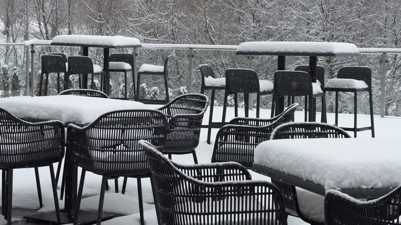 Tables and chairs covered with snow