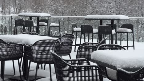 tables and chairs covered with snow