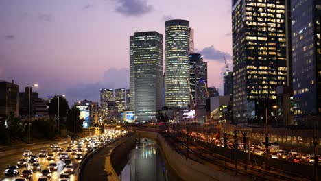 Toma-Estática-De-Atasco-De-Tráfico-En-La-Autopista-Ayalon-En-Tel-Aviv-Por-La-Noche-Con-Vista-Del-Rascacielos-En-El-Lado-Derecho,-Israel