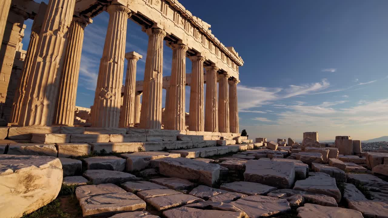 Low-angle video shot of ancient Greek ruins at sunset, highlighting the grandeur and texture