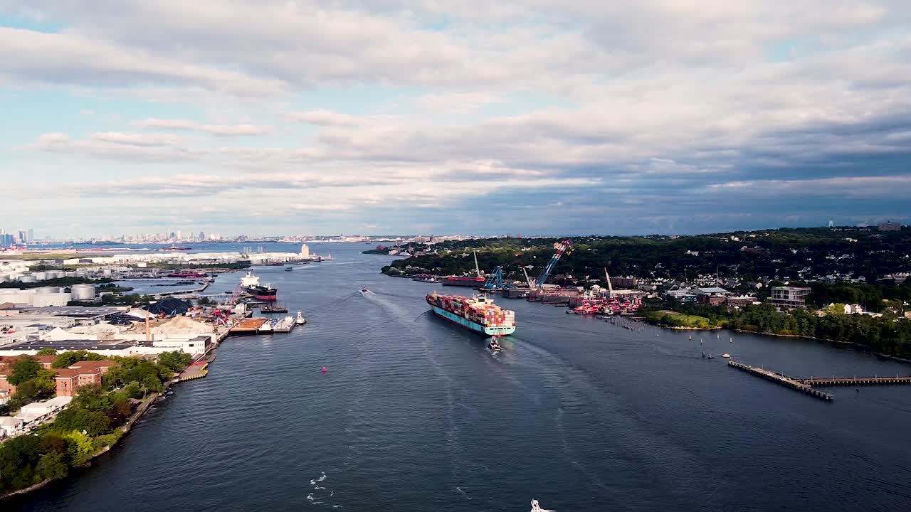 Cargo ship being taxied by tug boats to port near New York City - Aerial Drone footage far way from behind