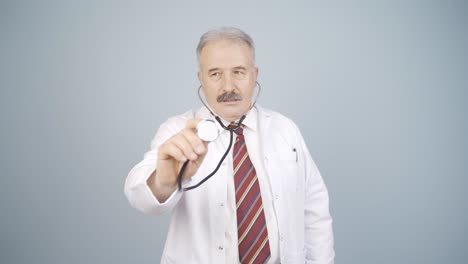 doctor listening to camera with stethoscope.