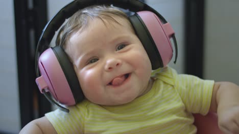 slow motion of baby with headphones sticking tongue out