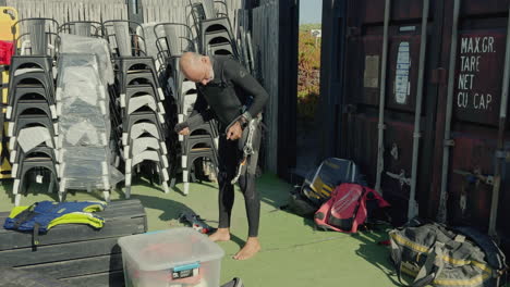 kite surfer checking and preparing to put on waist harness with ropes and carabiner