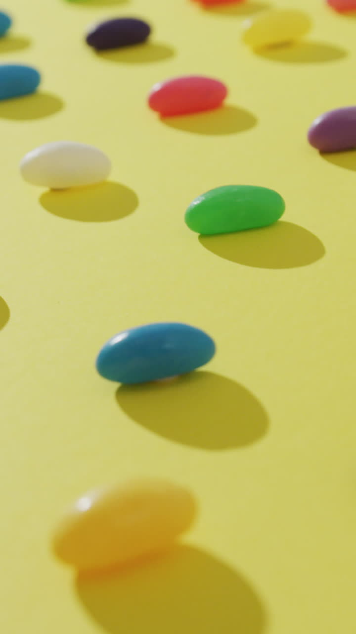 노란색 배경 위에 다채로운 과자 줄의 상공 전망의 비디오