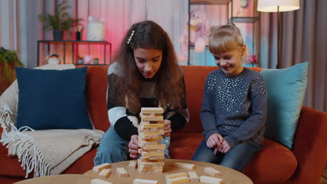 hermanos niños niñas jugando con bloques, juego de mesa, construir una torre de ladrillos de madera en casa