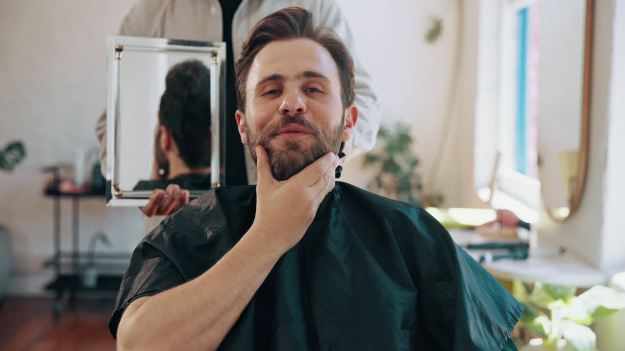 Glad mand tjekker sin nye frisure og skæg i barberspejlet