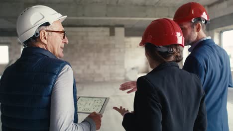 Video-De-Vista-Posterior-De-Un-Grupo-Caucásico-De-Ingenieros-E-Inversores-Ambulantes-En-Un-Sitio-De-Construcción