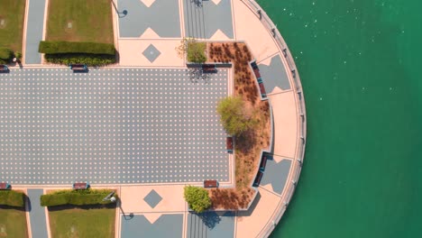 Toma-Aérea-De-Una-Plaza-Moderna-En-Abu-Dhabi-Cerca-Del-Agua-Y-Una-Autopista