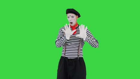 mime leans to invisible wall on a green screen, chroma key