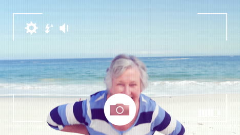 animación de la interfaz digital de la cámara sobre la mujer caucásica senior divirtiéndose en la playa