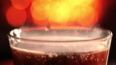 Cola-with-splashing-bubbles-slow-motion-on-a-blurry-light-,blurry-background.