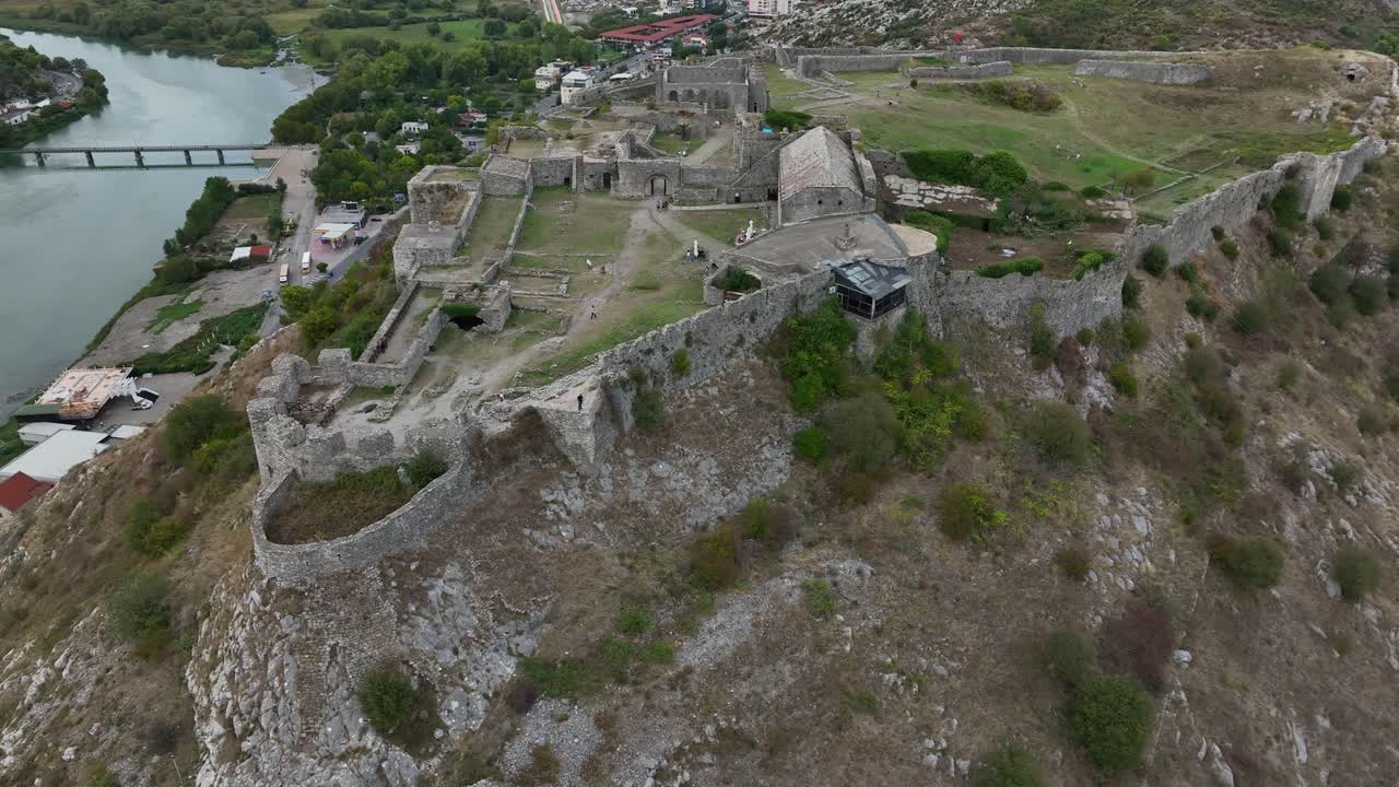 Drone establishing orbit of historic fortifications and rugged landscapes in Scodra, Albania overlooking city