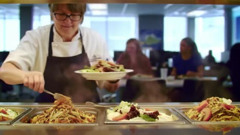 culinary expertise on display: a chef skillfully prepares plates of freshly made dishes in a busy dining environment, showcasing appetizing salads and pasta creations