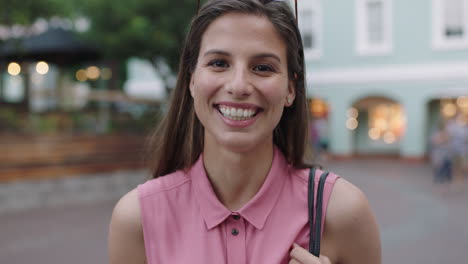 Retrato-En-Cámara-Lenta-De-Una-Joven-Hermosa-Mujer-Con-Blusa-Rosa-Riéndose-Alegre-De-La-Cámara-Por-La-Noche-Fondo-Urbano