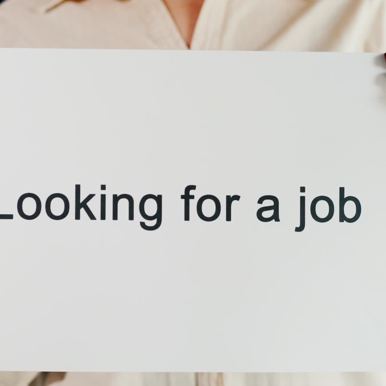 um homem segura um cartaz sobre como encontrar um emprego
